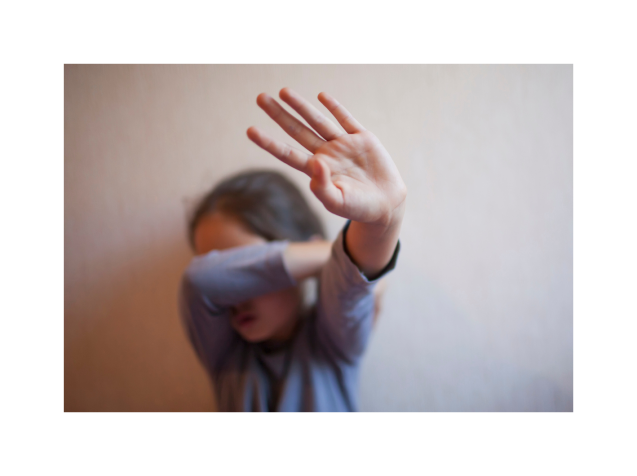 Child covering face with hand up