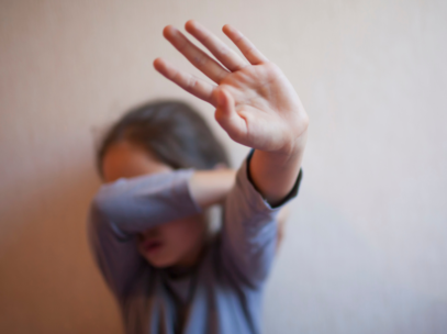 Child covering face with hand up